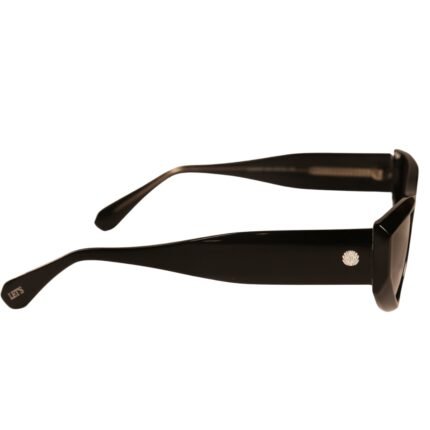 Vista lateral do óculos de sol preto modelo Lilium da Use Let’s Brasil, com armação em acetato preto de acabamento brilhante, detalhe metálico com logo na haste e inscrição LET’S na ponta da haste, sobre fundo branco neutro