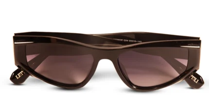 Óculos de sol preto modelo Lilium da Use Let’s Brasil, com armação em acetato preto de design levemente gatinho, lentes escuras com proteção UV400 e detalhe metálico na haste, sobre fundo branco neutro